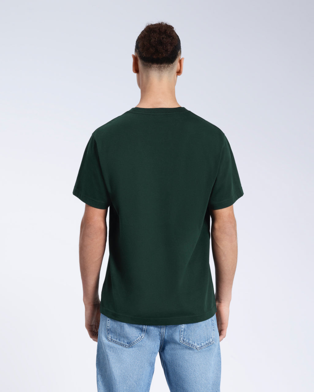 A man facing away from the camera, modelling a plain green short sleeve organic cotton t shirt.