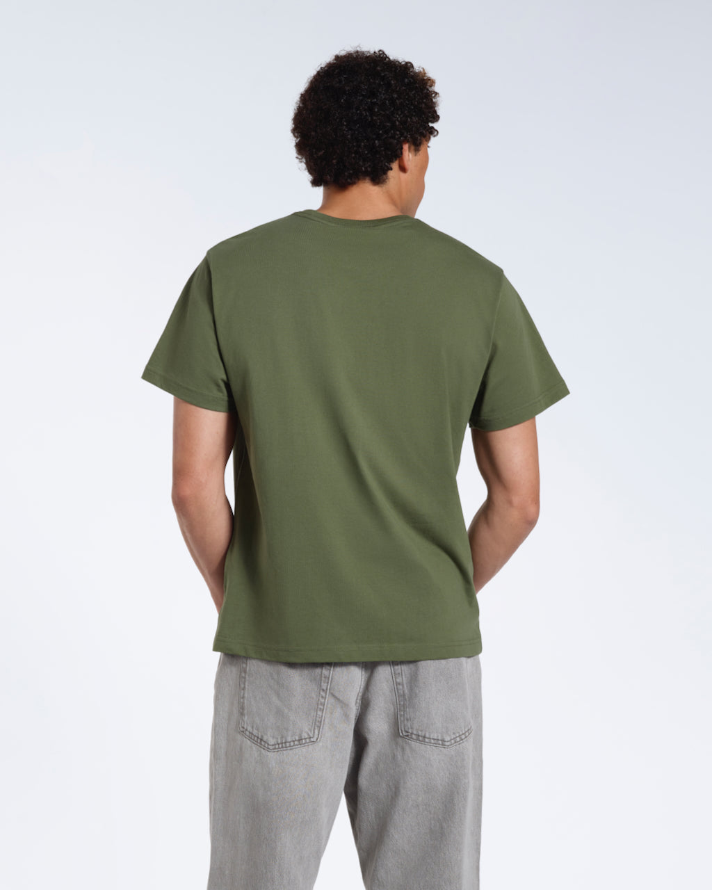 A man facing away from the camera, modelling a plain khaki green short sleeve organic cotton t shirt.