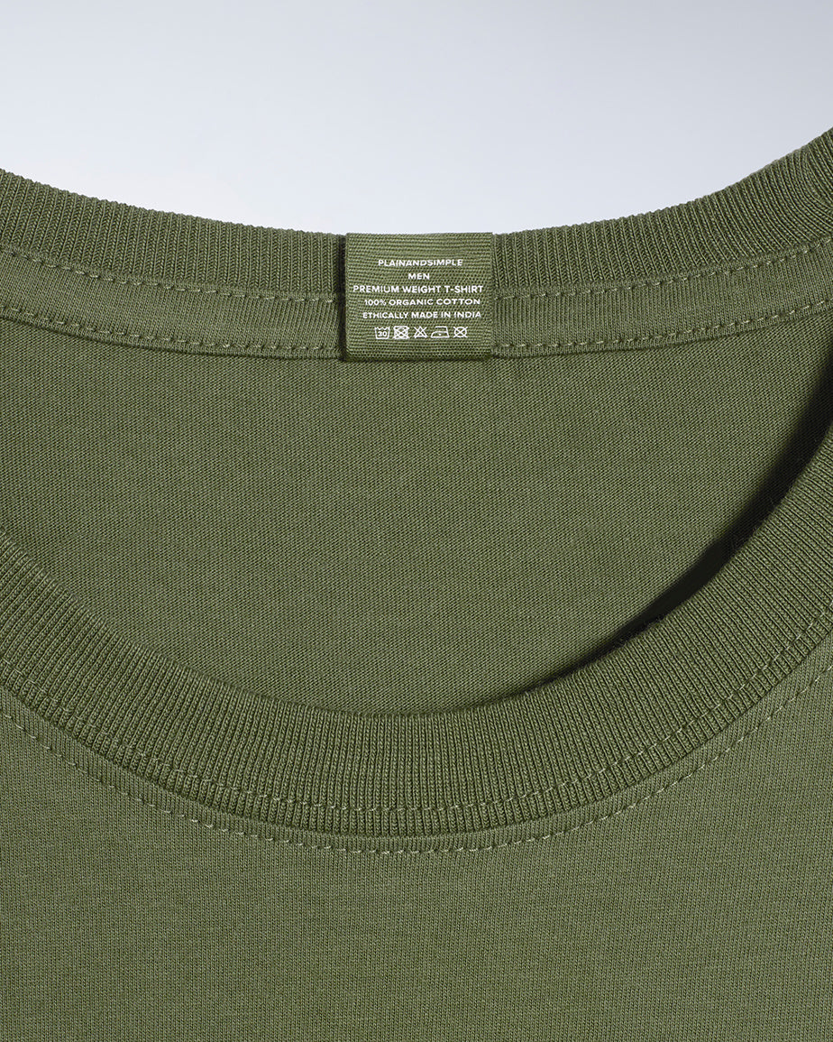 A close up of a neck label in a men's khaki green short sleeve crew neck organic cotton t shirt.