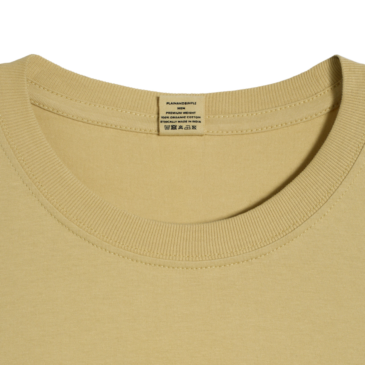 A close up of a neck label in a men's light khaki short sleeve crew neck organic cotton t shirt.
