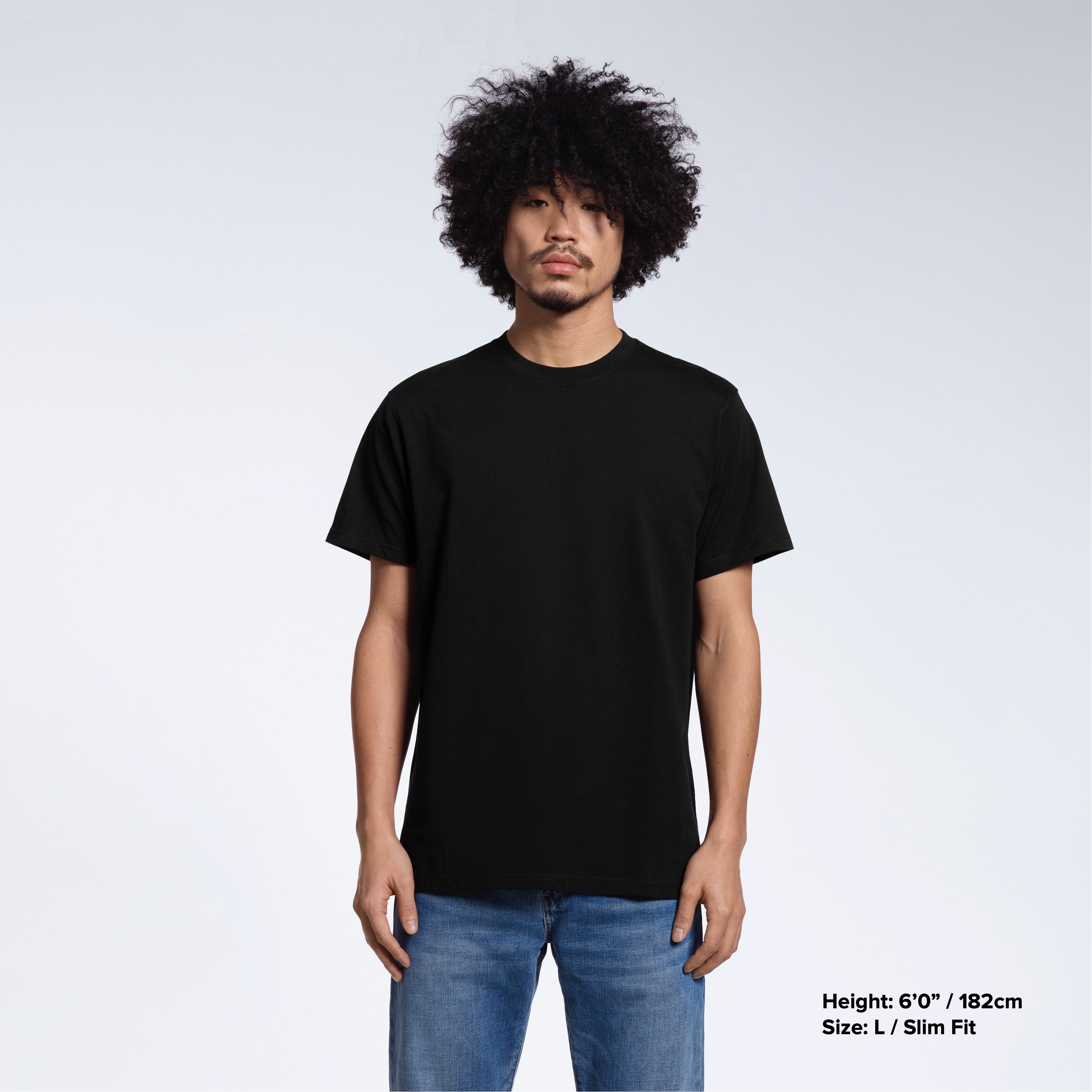 A man facing front on looking into the camera, modelling a plain black short sleeve organic cotton t shirt.
