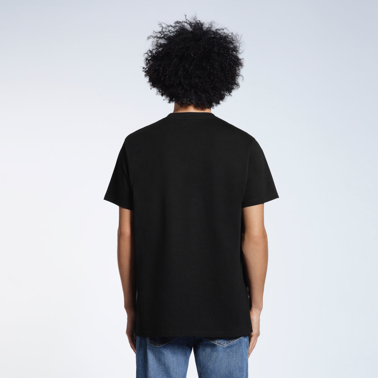 A man facing away from the camera, modelling a plain navy short sleeve organic cotton t shirt.