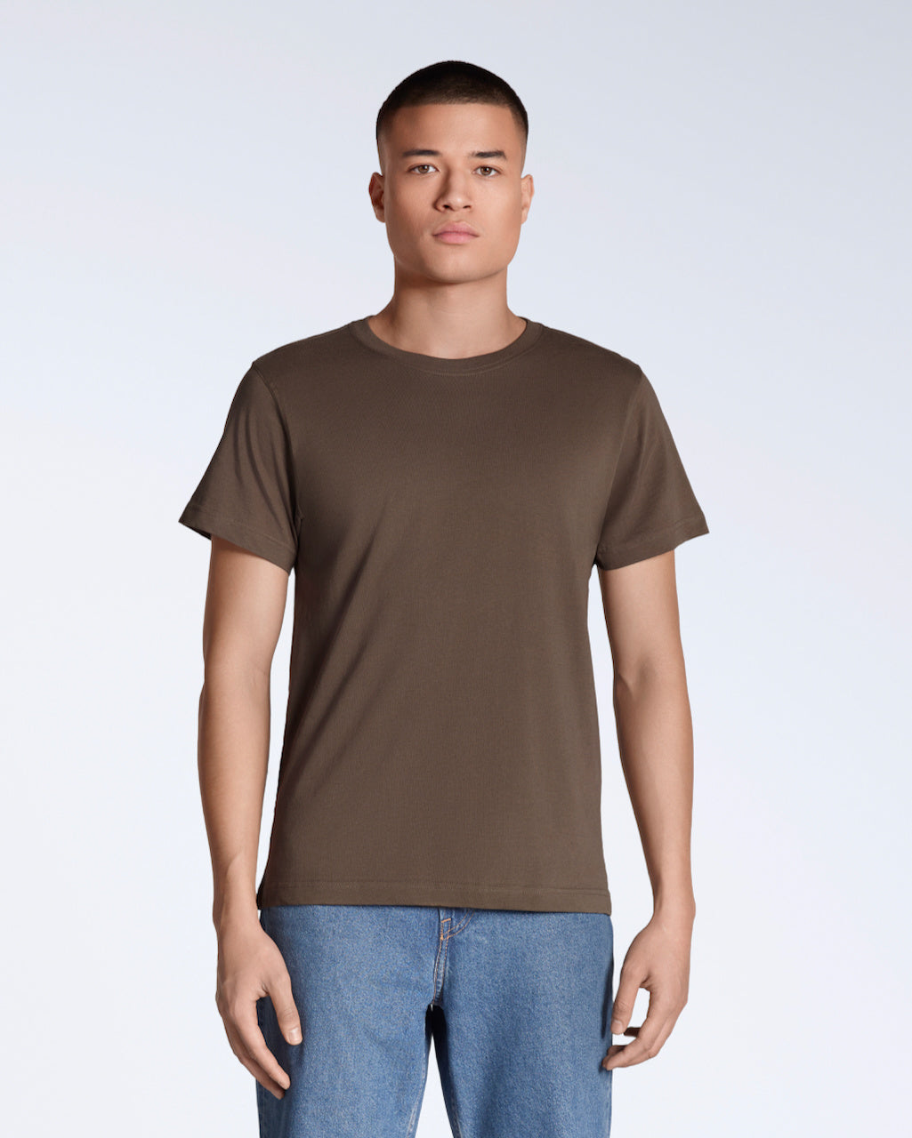 A man facing front on looking into the camera, modelling a plain brown short sleeve organic cotton t shirt.