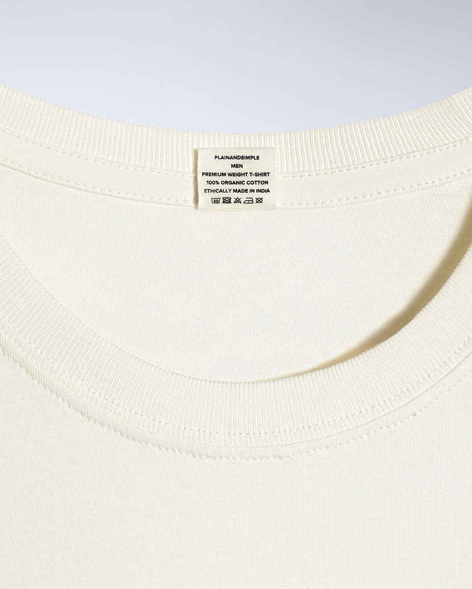 A close up of a neck label in a men's ecru short sleeve crew neck organic cotton t shirt.