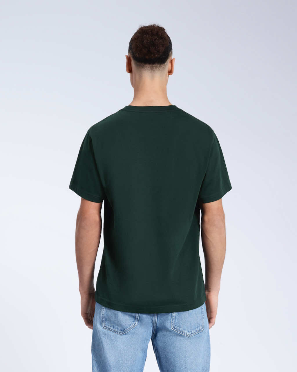 A man facing away from the camera, modelling a plain green short sleeve organic cotton t shirt.