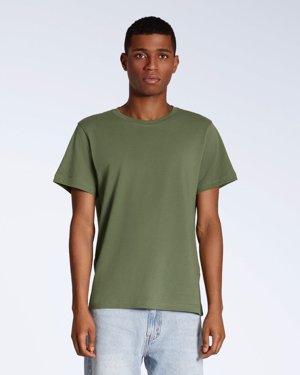 A man facing front on looking into the camera, modelling a plain khaki green short sleeve organic cotton t shirt.