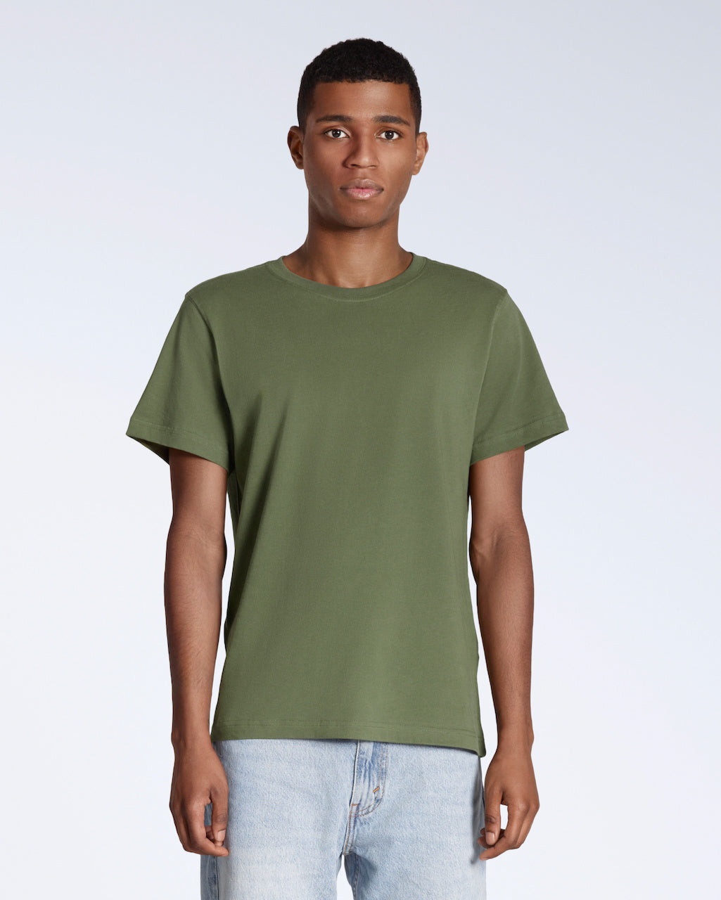 A man facing front on looking into the camera, modelling a plain khaki green short sleeve organic cotton t shirt.
