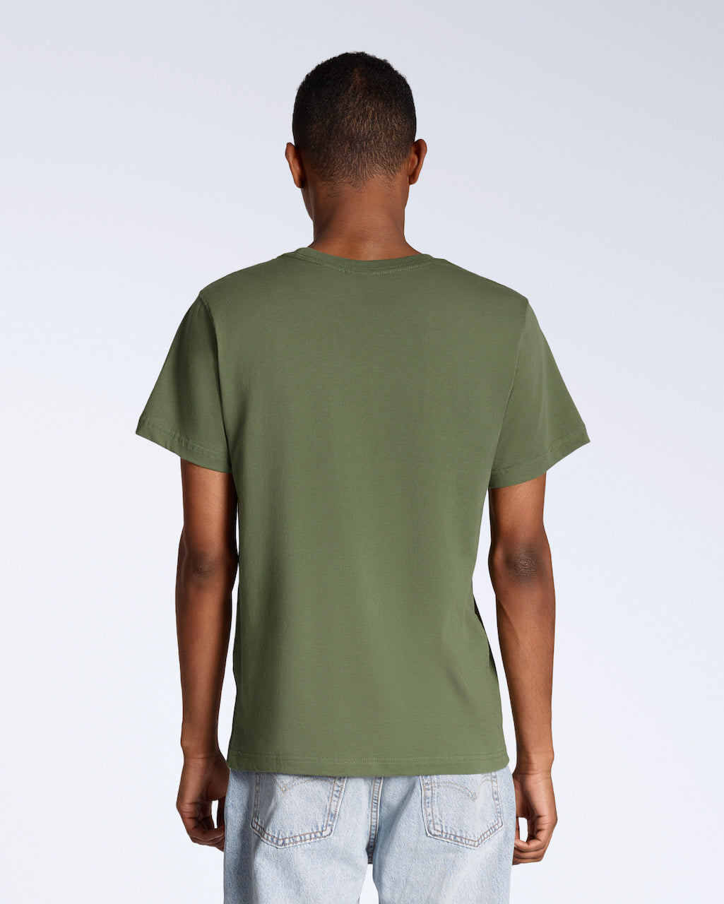 A man facing away from the camera, modelling a plain khaki green short sleeve organic cotton t shirt.