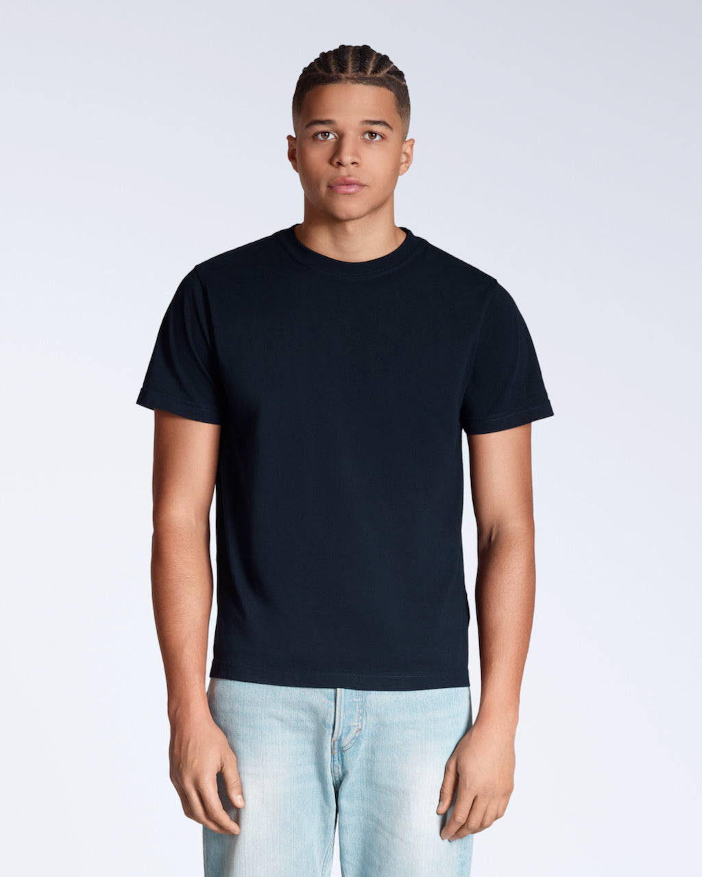 A man facing front on looking into the camera, modelling a plain navy short sleeve organic cotton t shirt.