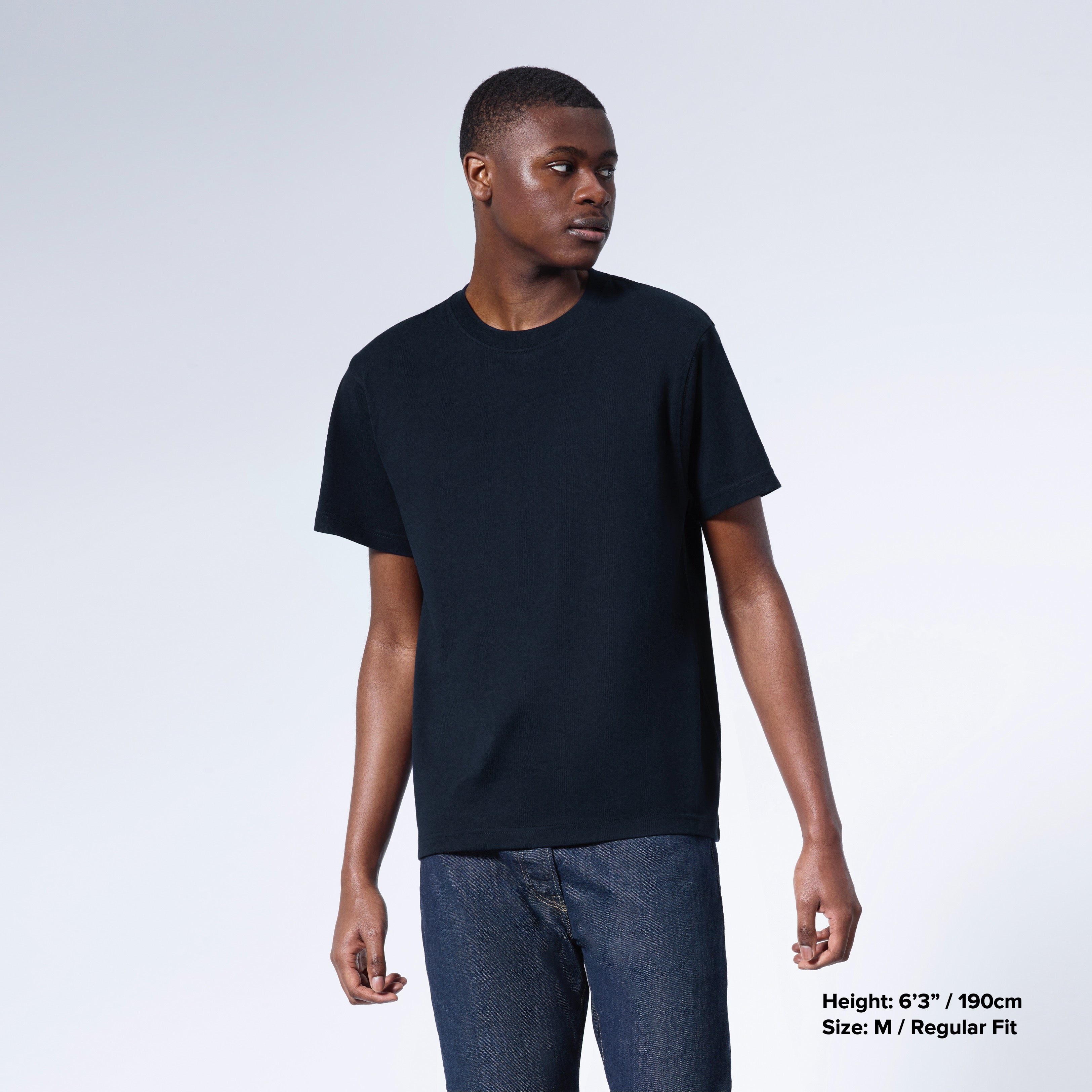 A man looking away from the camera, modelling a plain navy short sleeve organic cotton t shirt.