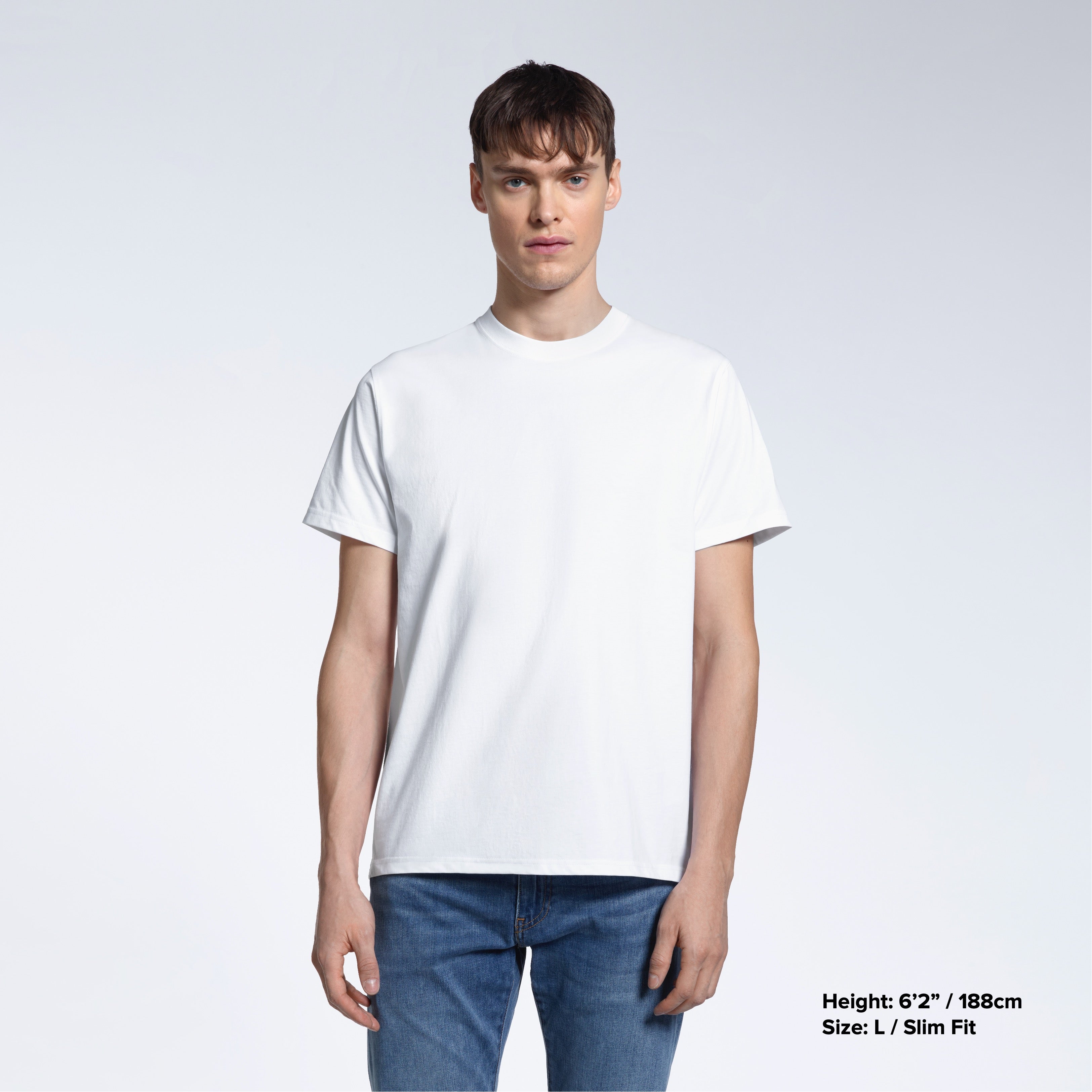 A man facing front on looking into the camera, modelling a plain white short sleeve organic cotton t shirt.