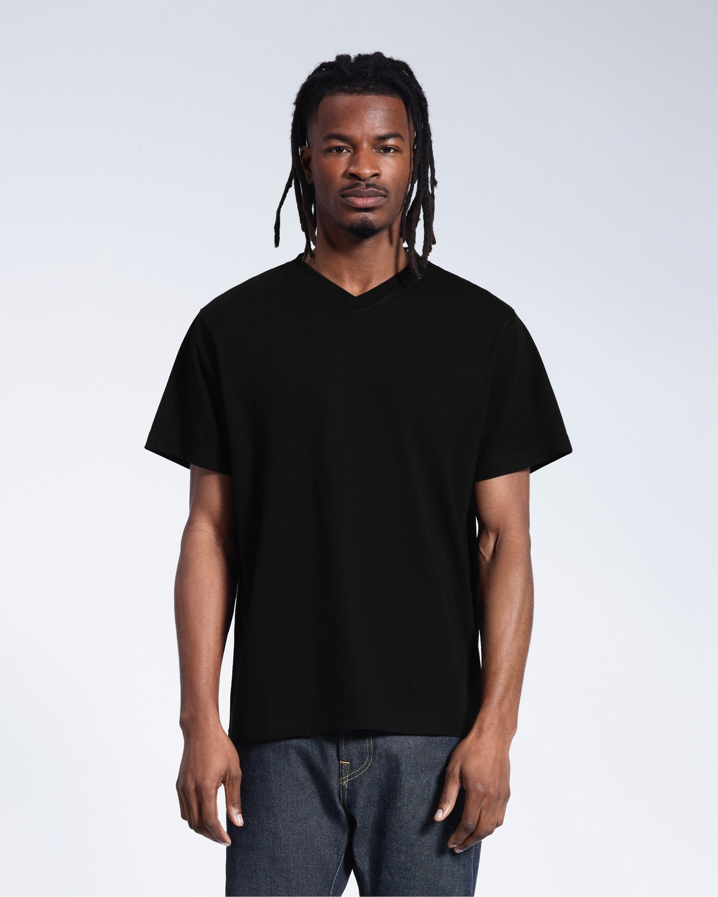 A man facing front on with his arms by his sides, modelling a plain black organic cotton v neck t shirt.