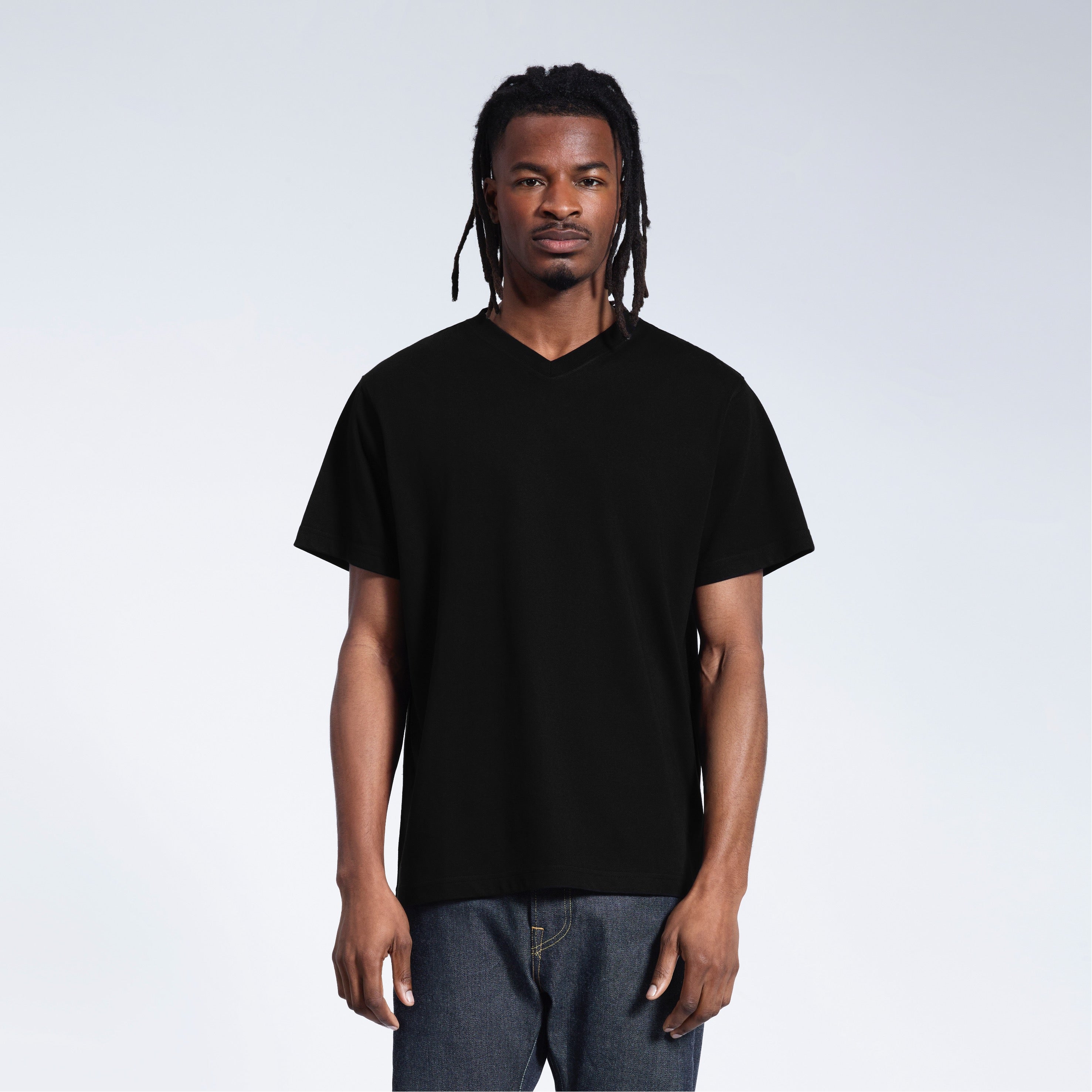 A man facing front on with his arms by his sides, modelling a plain black organic cotton v neck t shirt.