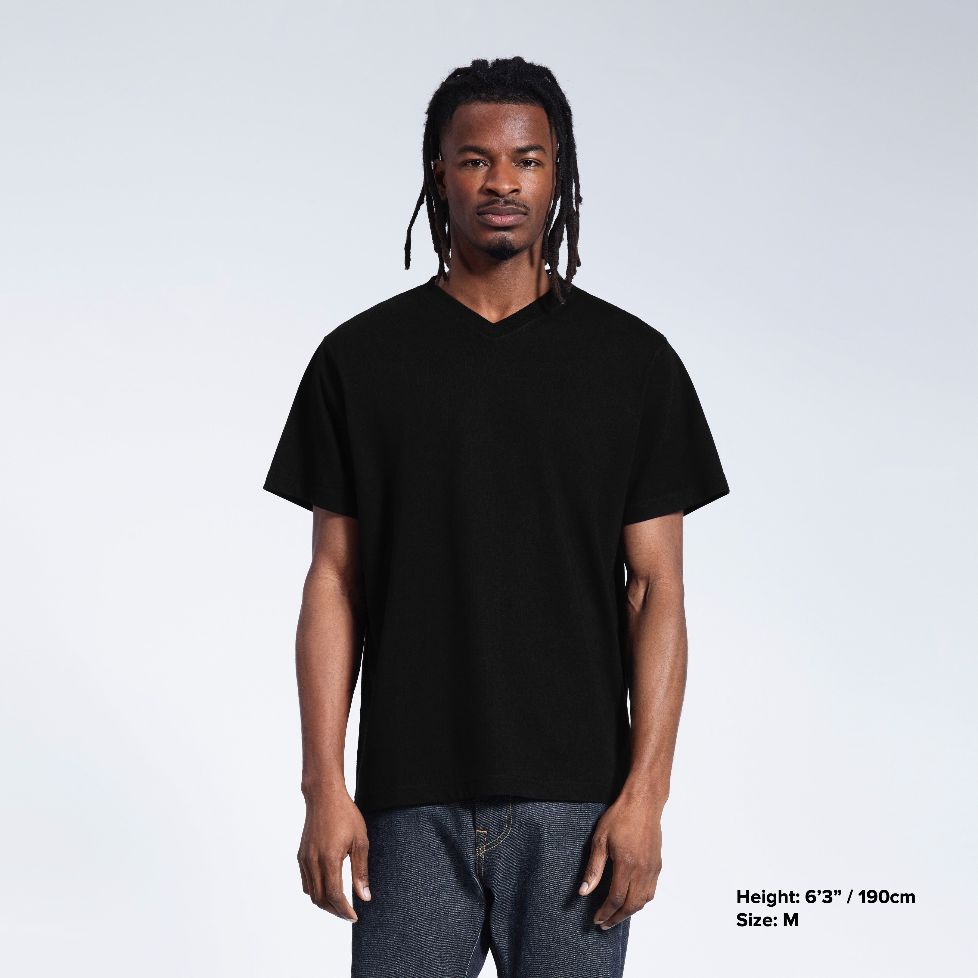 A man facing front on with his arms by his sides, modelling a plain black organic cotton v neck t shirt.
