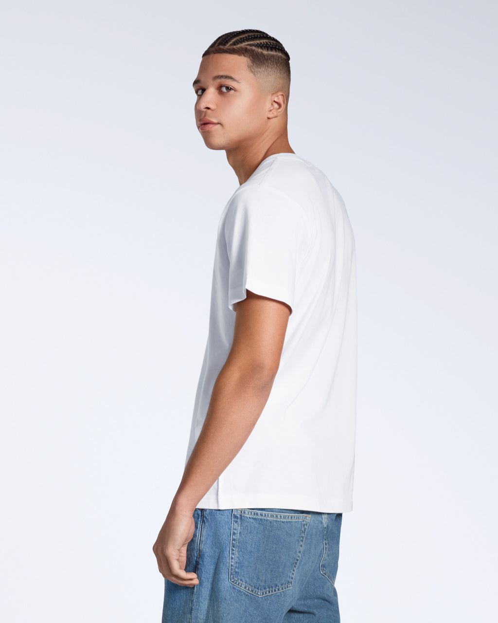 A man looking over his shoulder to the camera, modelling a plain white, organic cotton v neck t shirt.