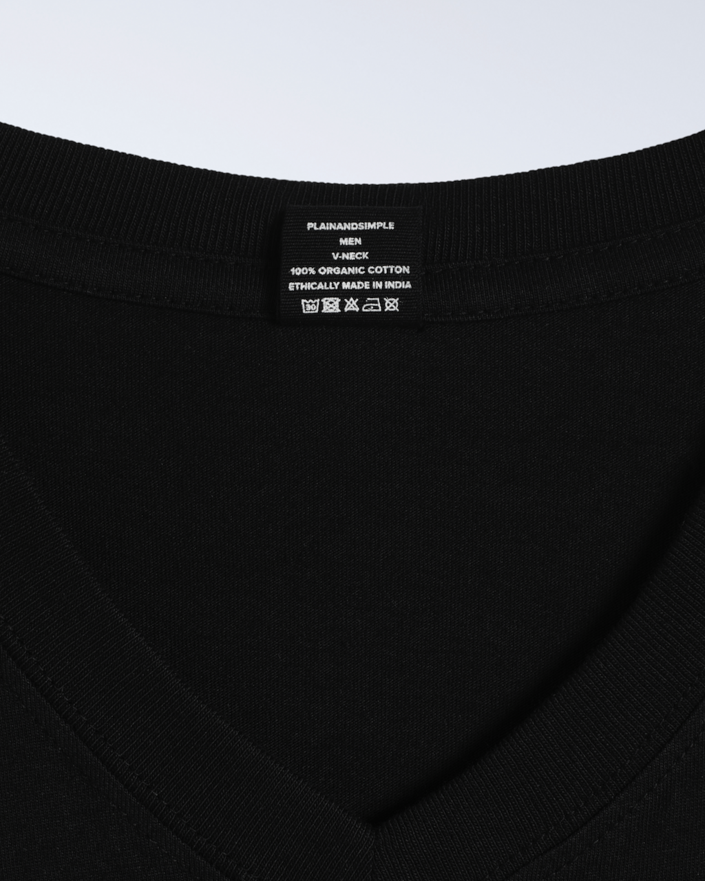 A close up of the label in a black, v neck, organic cotton t shirt.