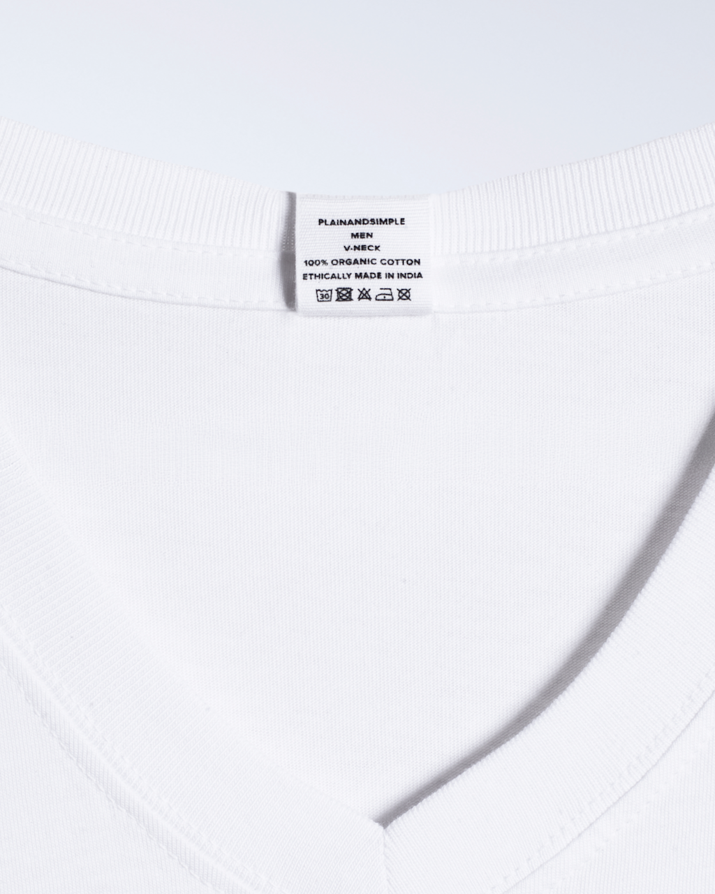 A close up of the label in a white, v neck, organic cotton t shirt.