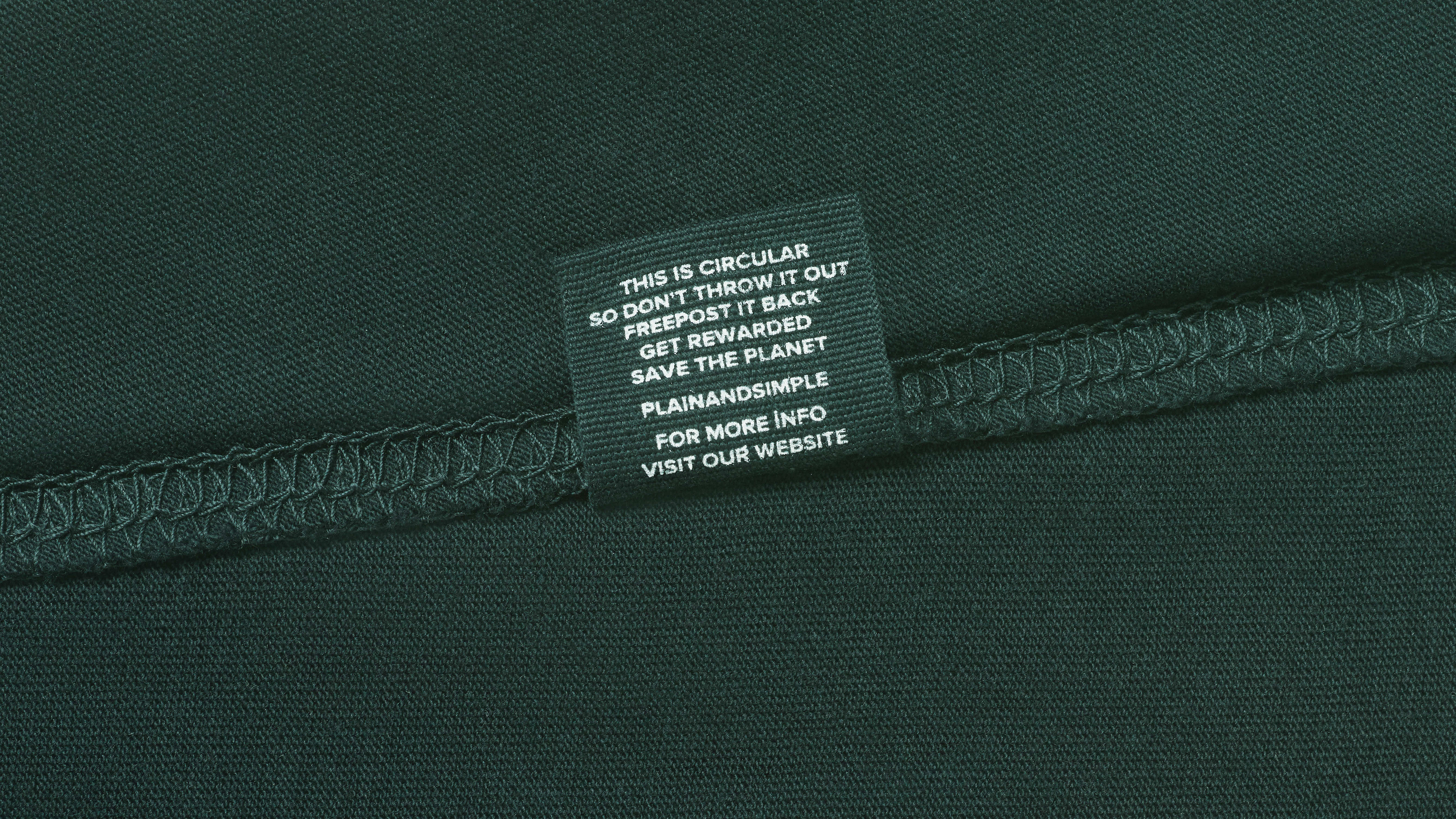 A close up of a care label in a green organic cotton t shirt.