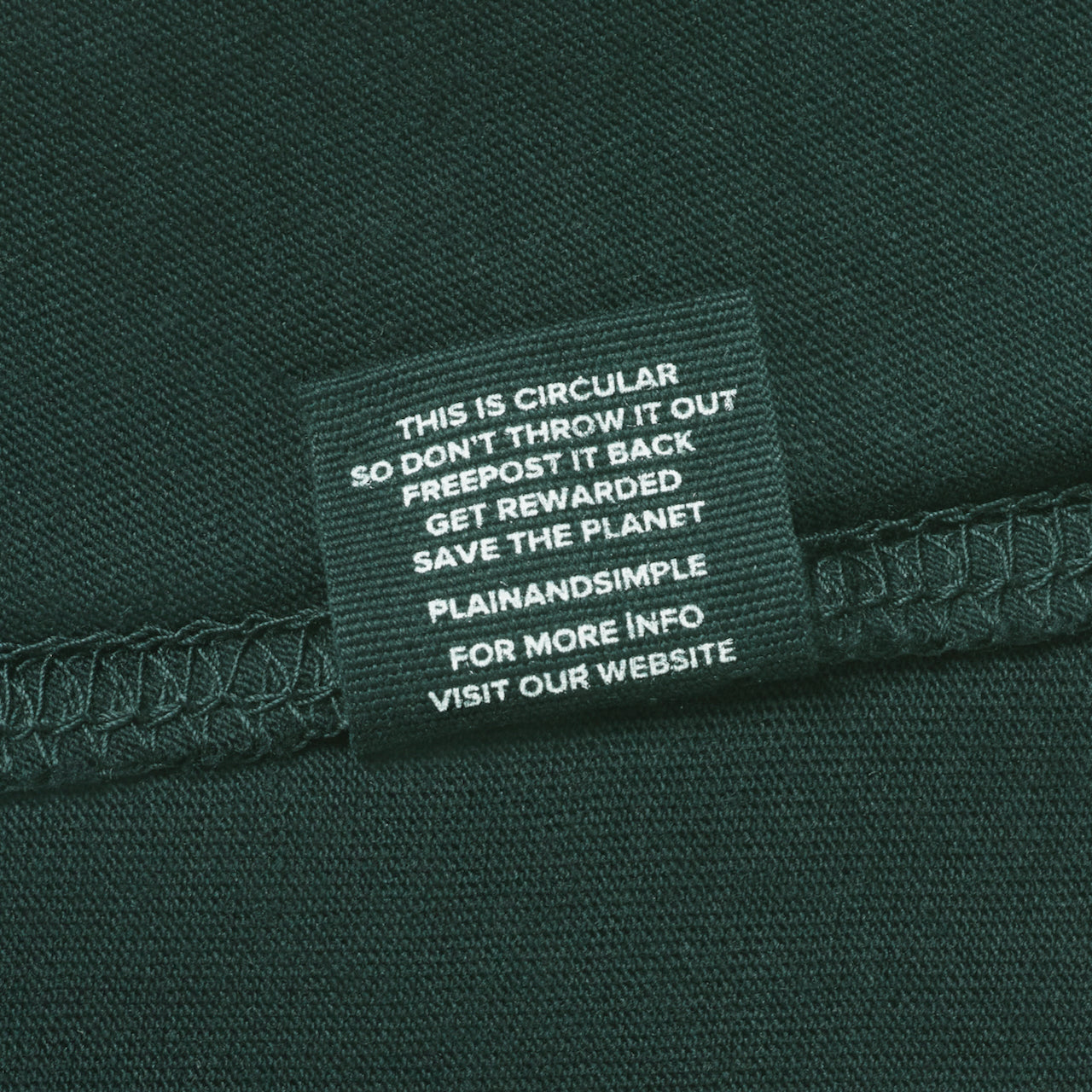 A close up of a care label in a green organic cotton t shirt.