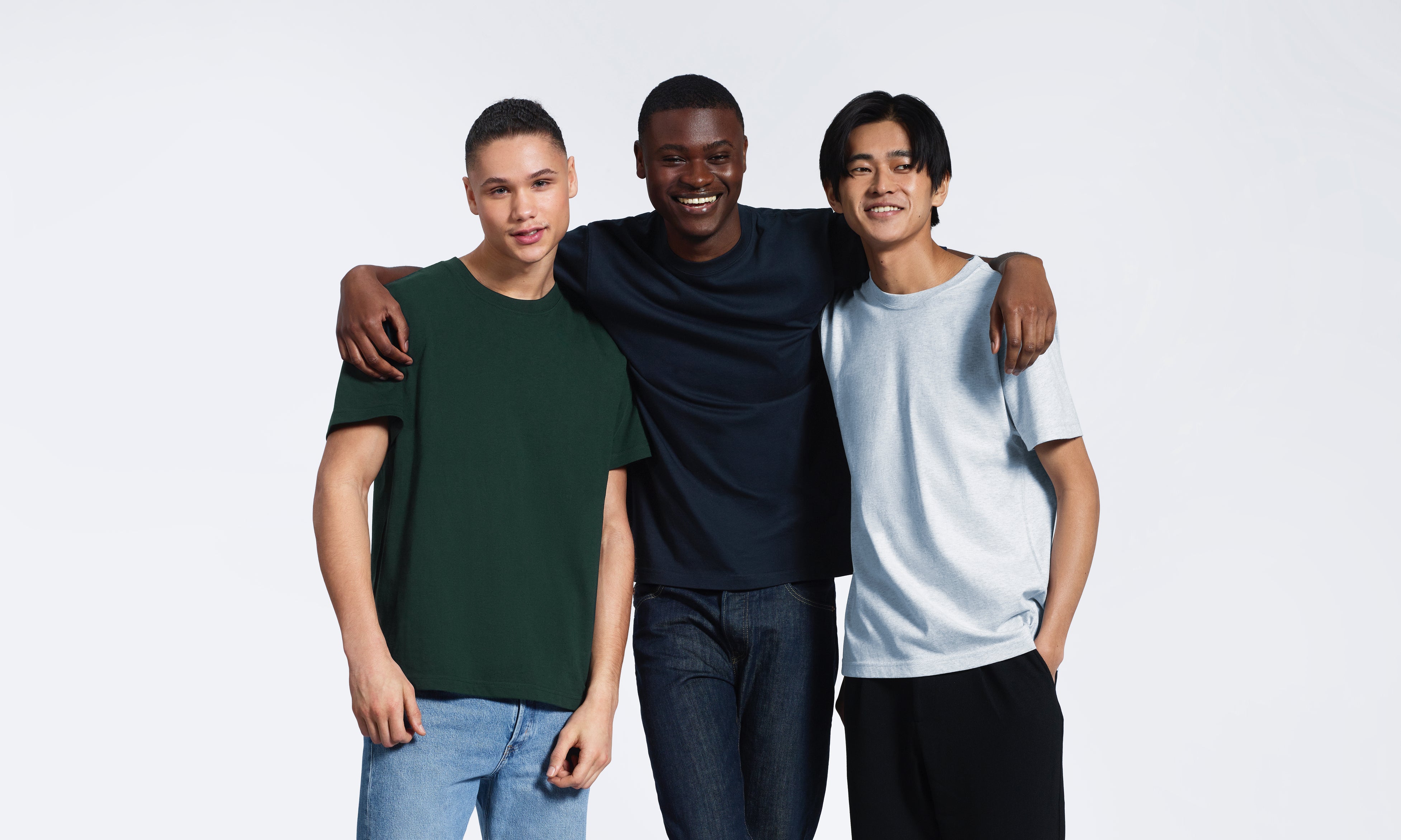 Three men modelling green, navy and grey t-shirts.