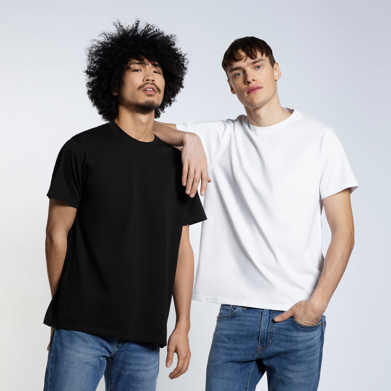 Two men looking at the camera, modelling plain short sleeve, black and white organic cotton t shirts.