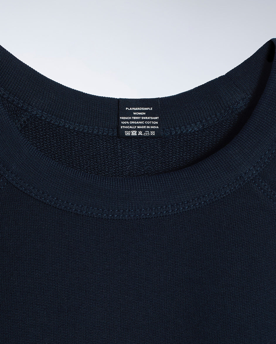 A close up of an neck label in a women's navy organic cotton sweatshirt.