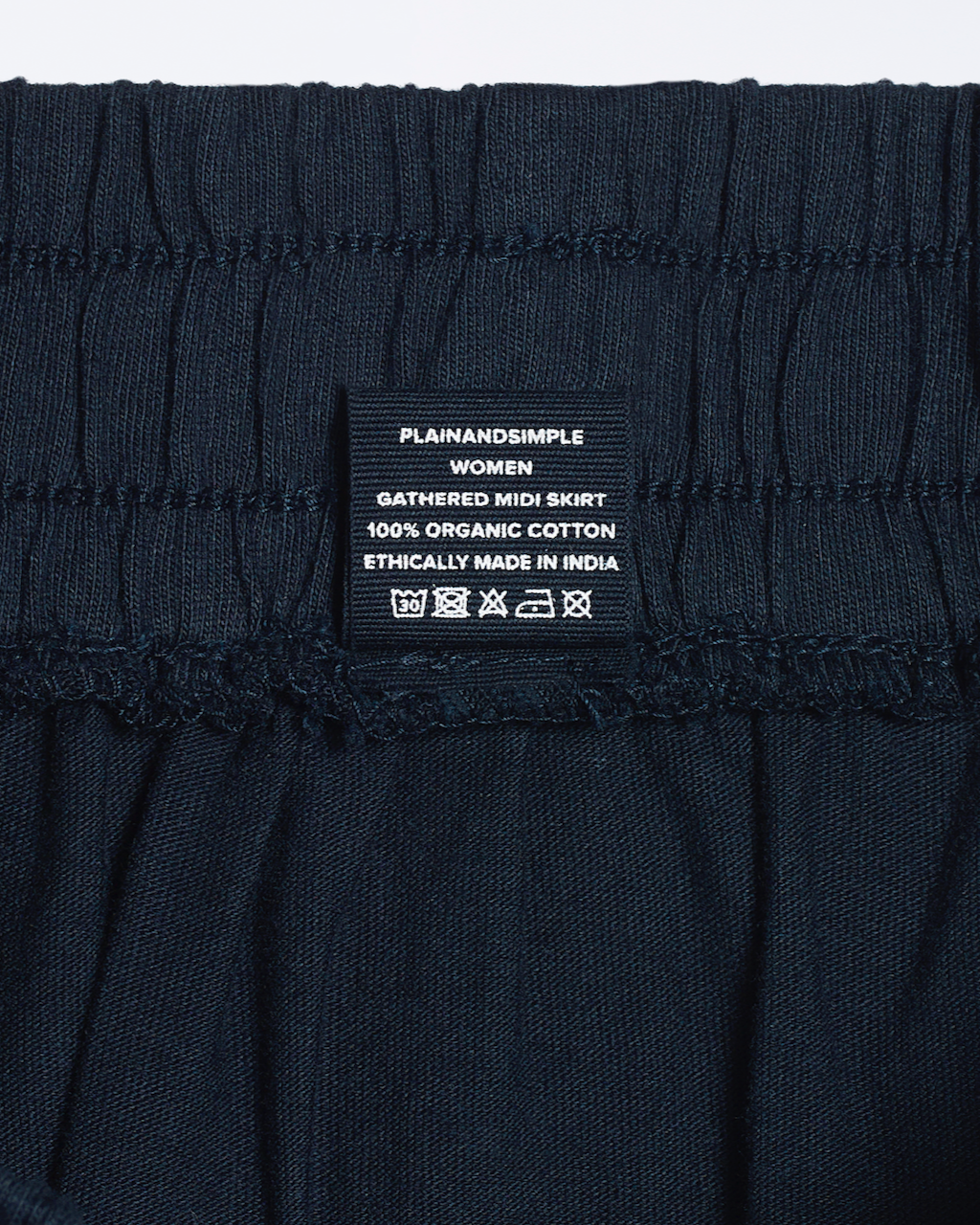A close up of a clothing label for an organic cotton midi skirt.
