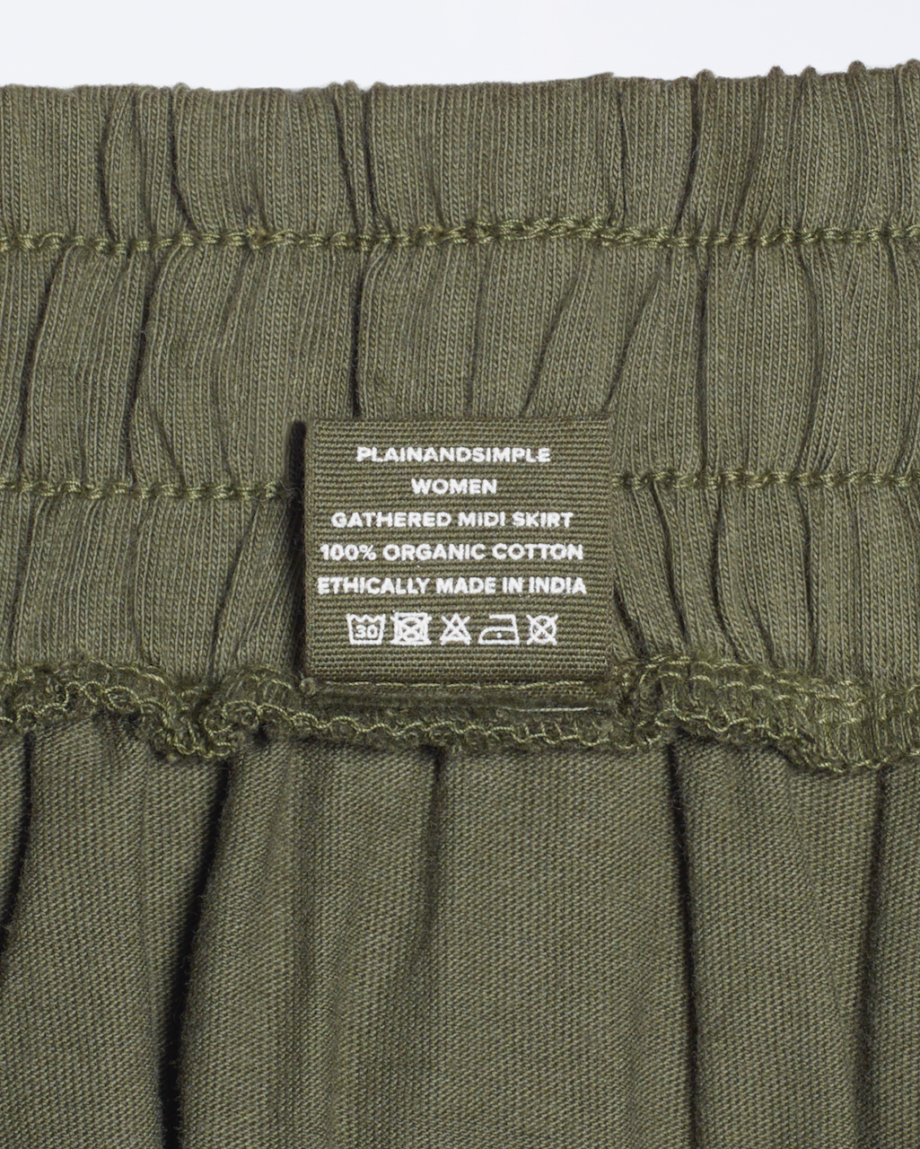 A close up of a clothing label for an organic cotton midi skirt.