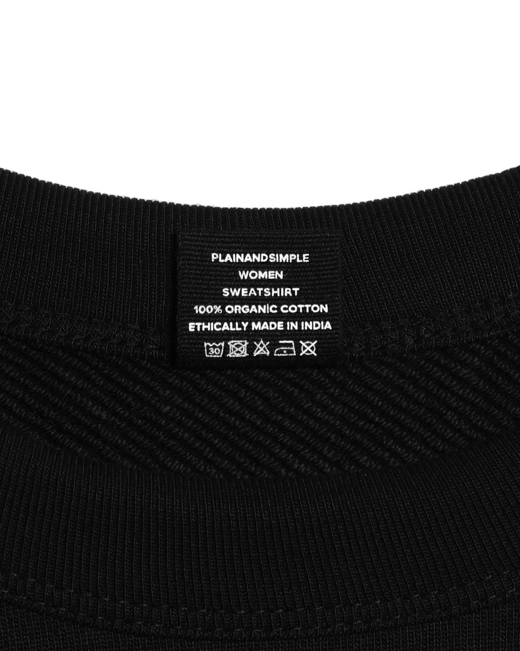 A close up of an neck label in a women's black heavyweight organic cotton sweatshirt.
