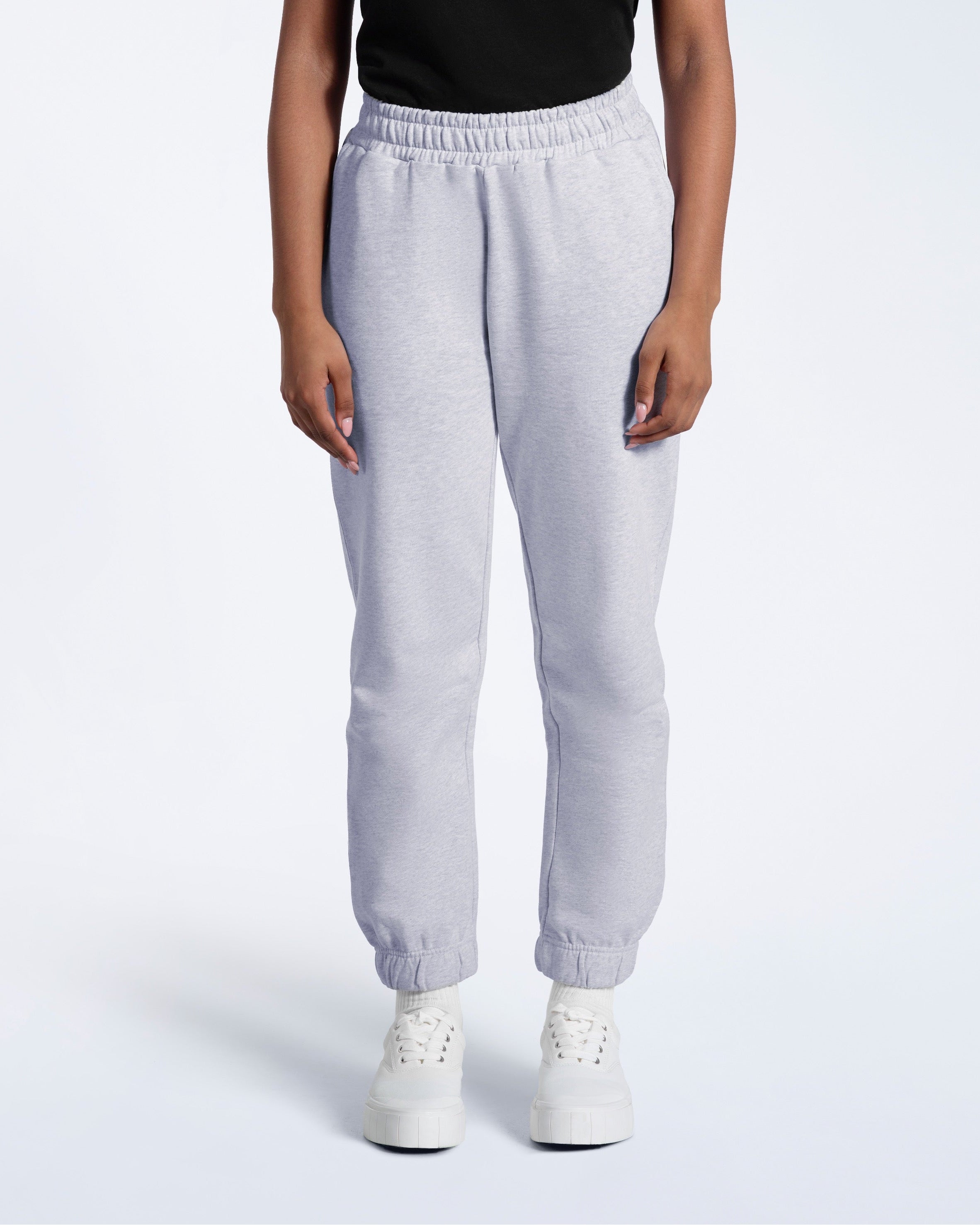 A person with their arms by their sides, modelling a pair of women's grey heavyweight organic cotton joggers.