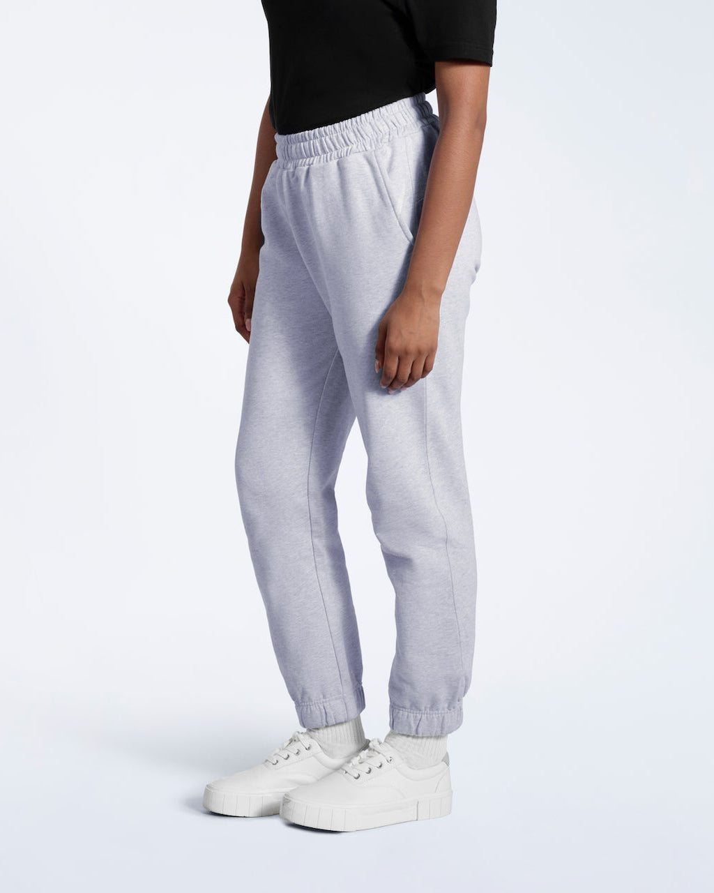A person facing side on, modelling a pair of women's grey heavyweight organic cotton joggers.