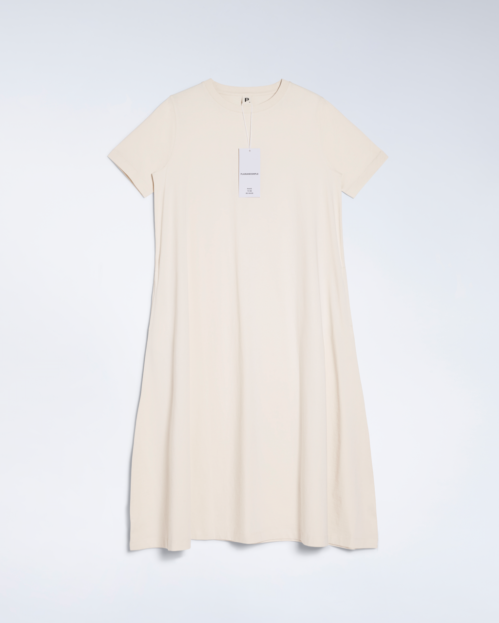 A flatlay of a natural coloured, long line, organic cotton t shirt dress.