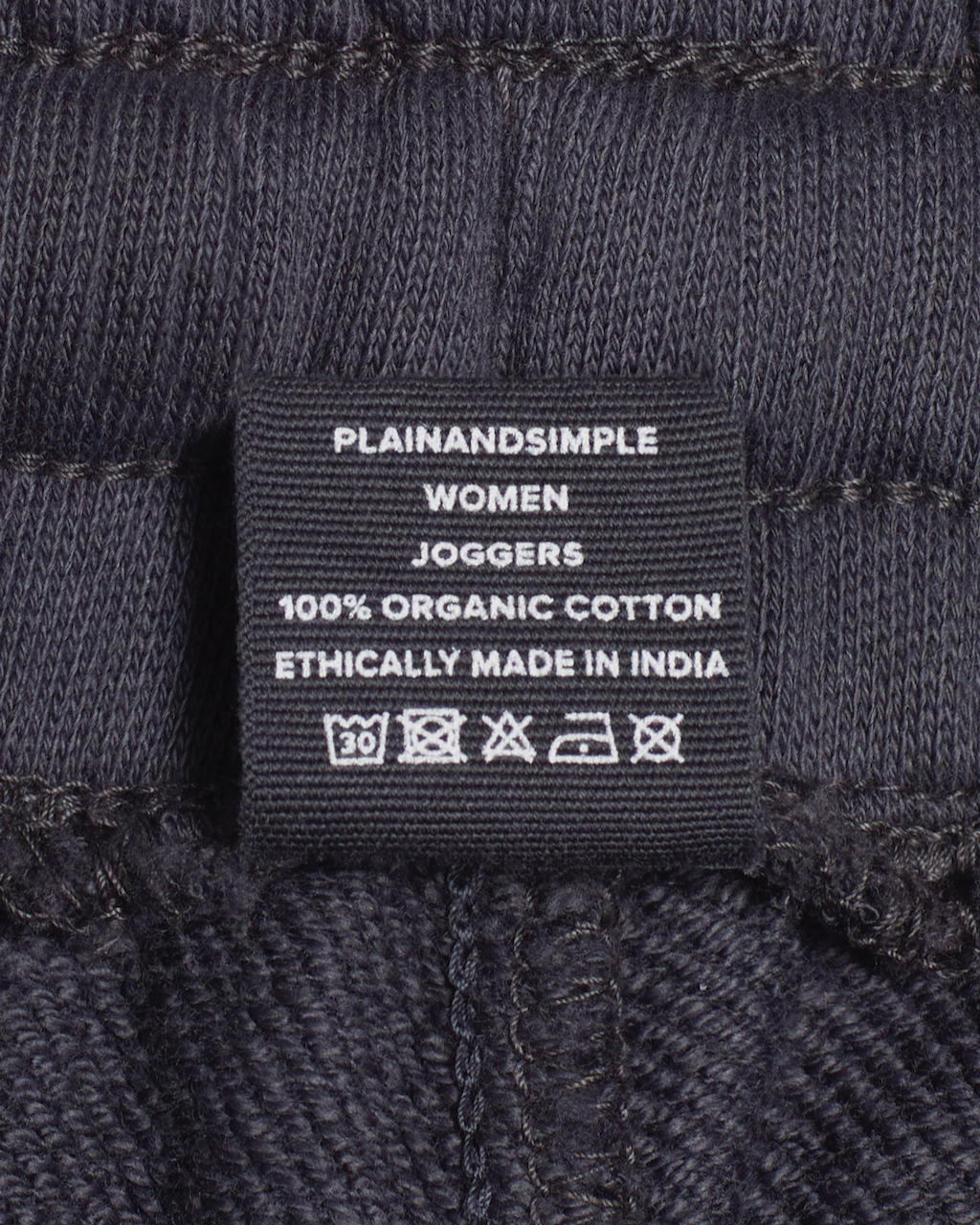 A close up of the label in a pair of dark grey, organic cotton joggers.