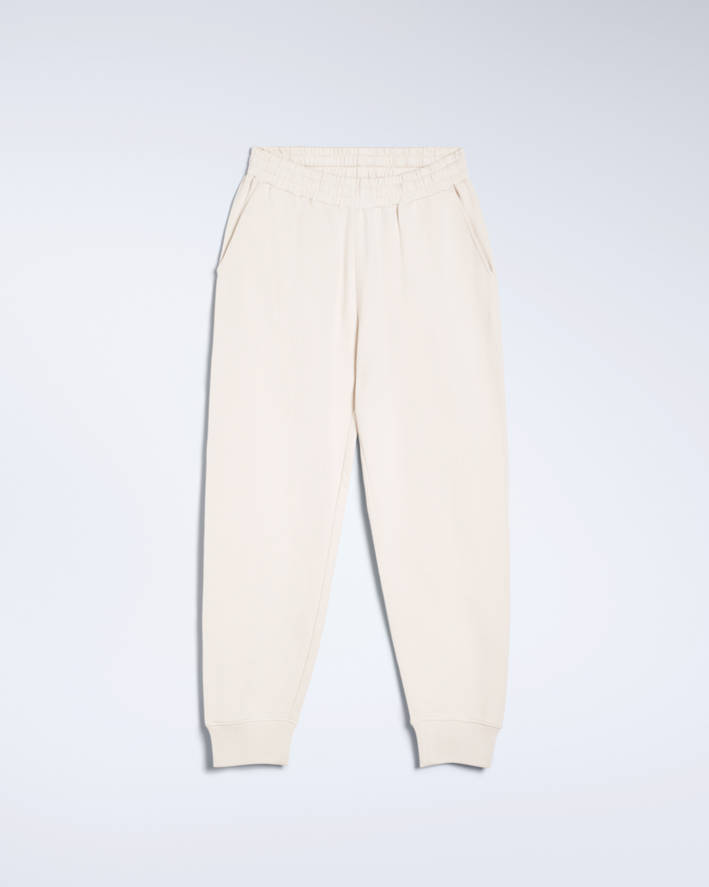A flatlay of a pair of natural coloured, organic cotton joggers.