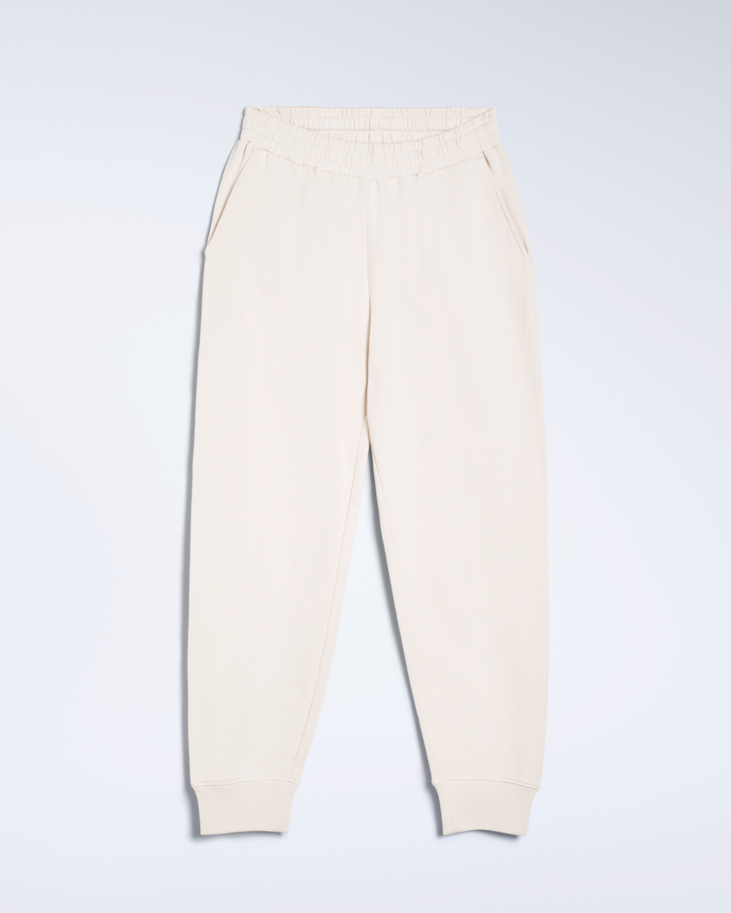 A flatlay of a pair of natural coloured, organic cotton joggers.