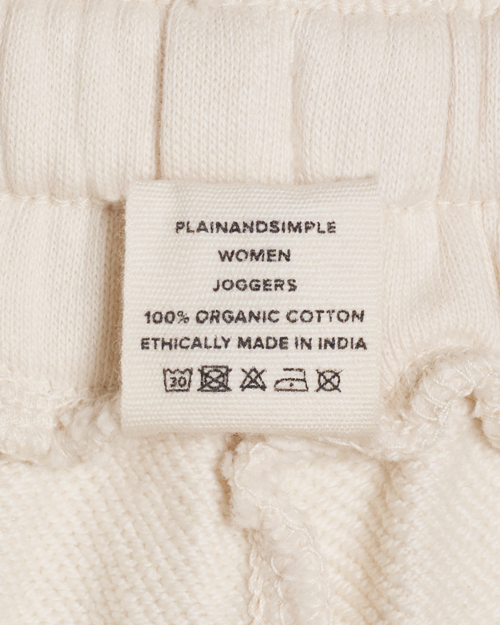 A close up of the label in a pair of natural coloured, organic cotton joggers.