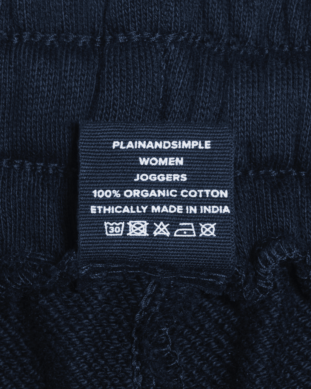 A close up of the label in a pair of navy, organic cotton joggers.
