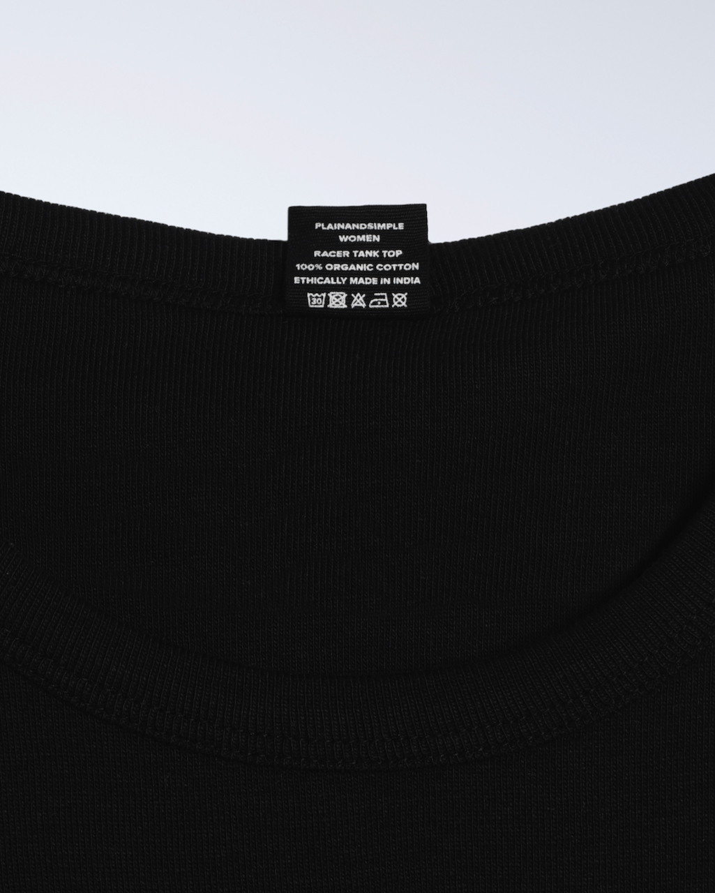 A close up of a neck label, for a black, organic cotton tank top.