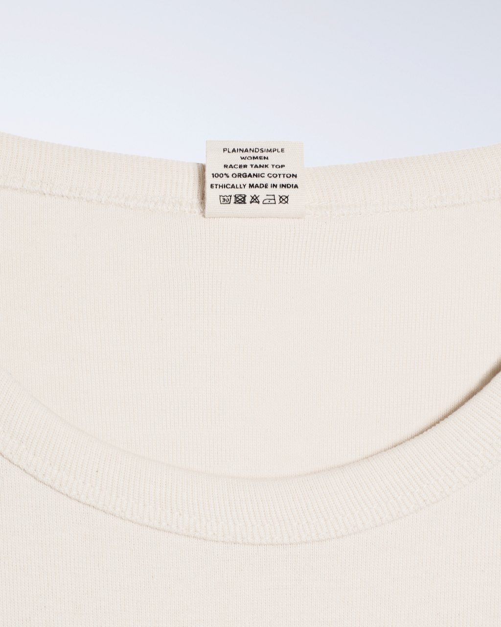 A close up of a neck label, for a natural coloured, organic cotton tank top.