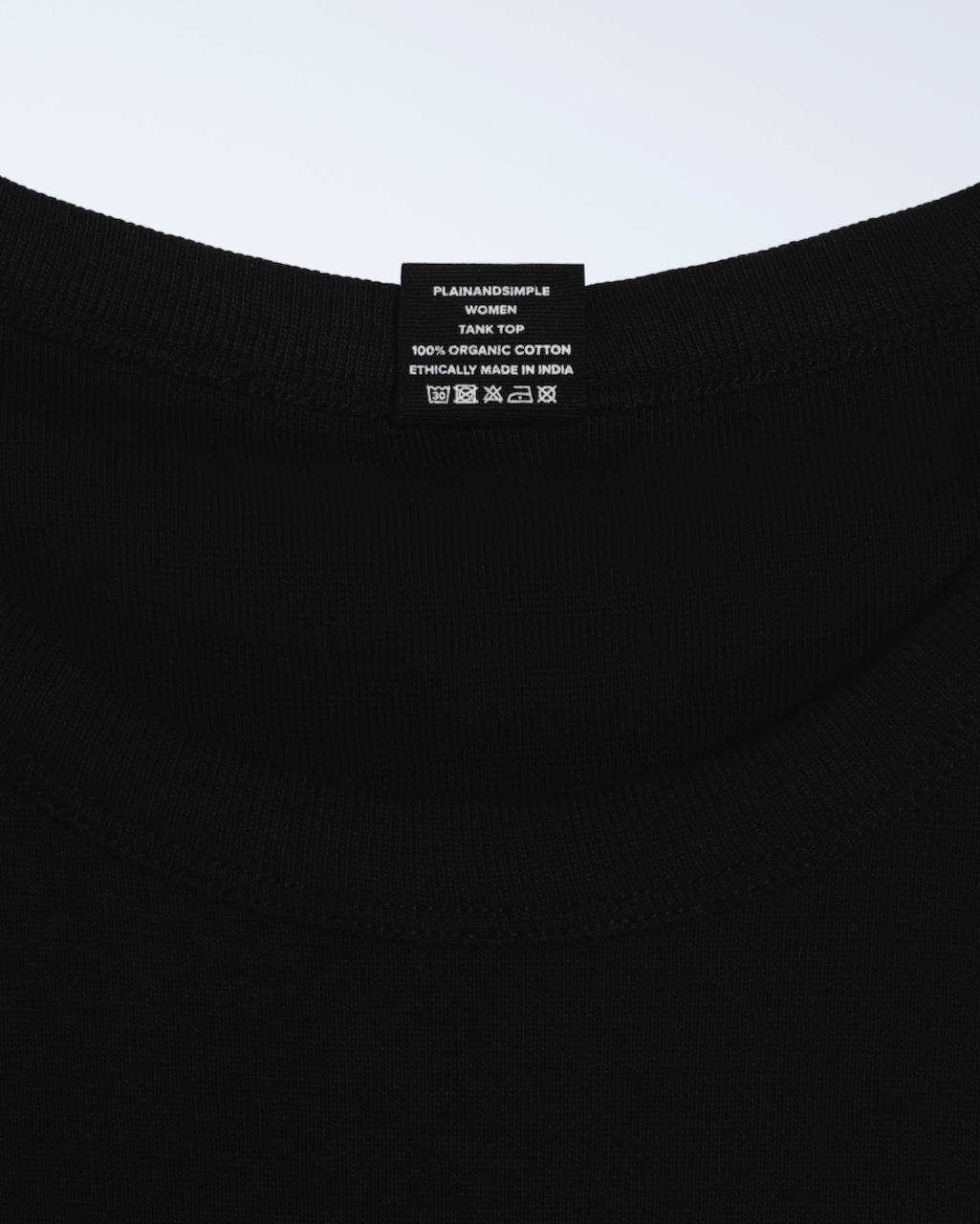 A close up of a neck label, for a black, organic cotton tank top.
