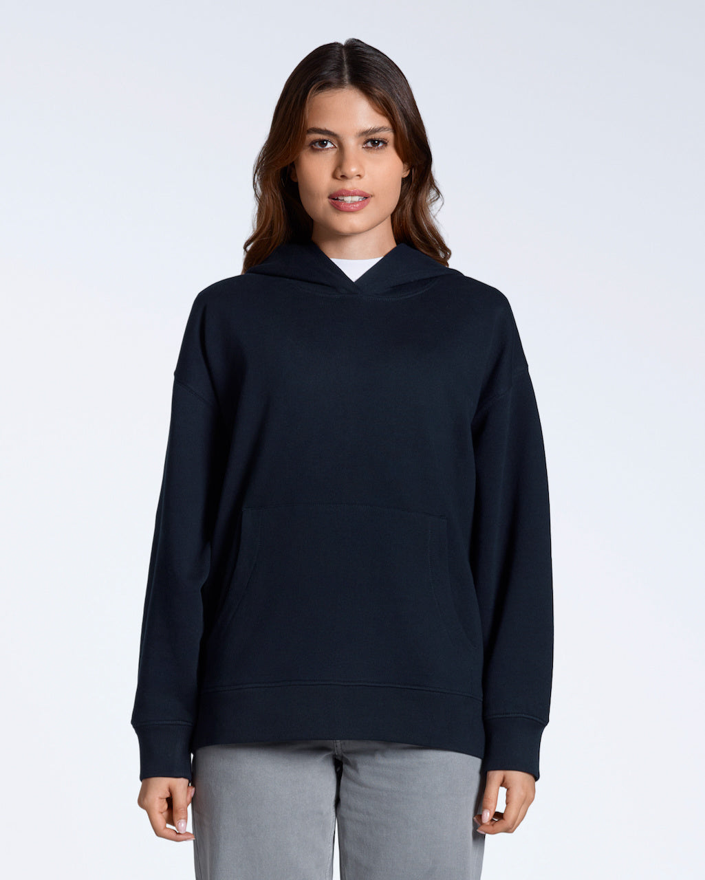 A woman facing front on, modelling a plain navy, oversized, organic cotton hoodie.