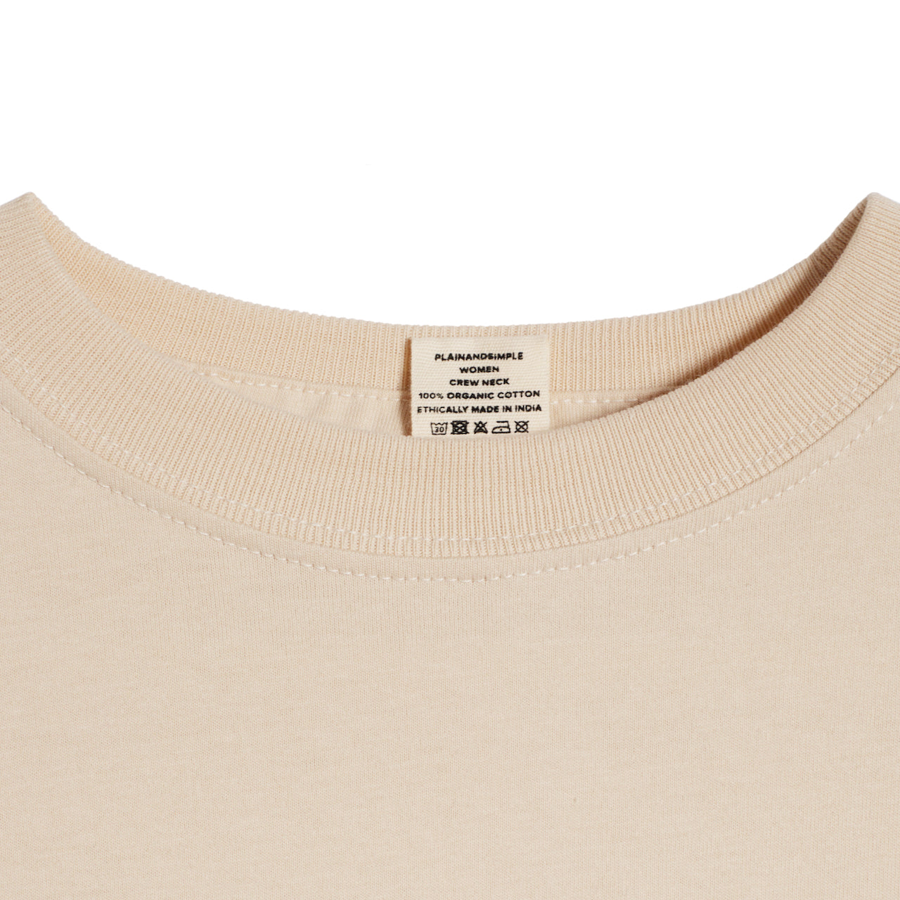 A close up of a neck label in a women's beige short sleeve crew neck organic cotton t shirt.