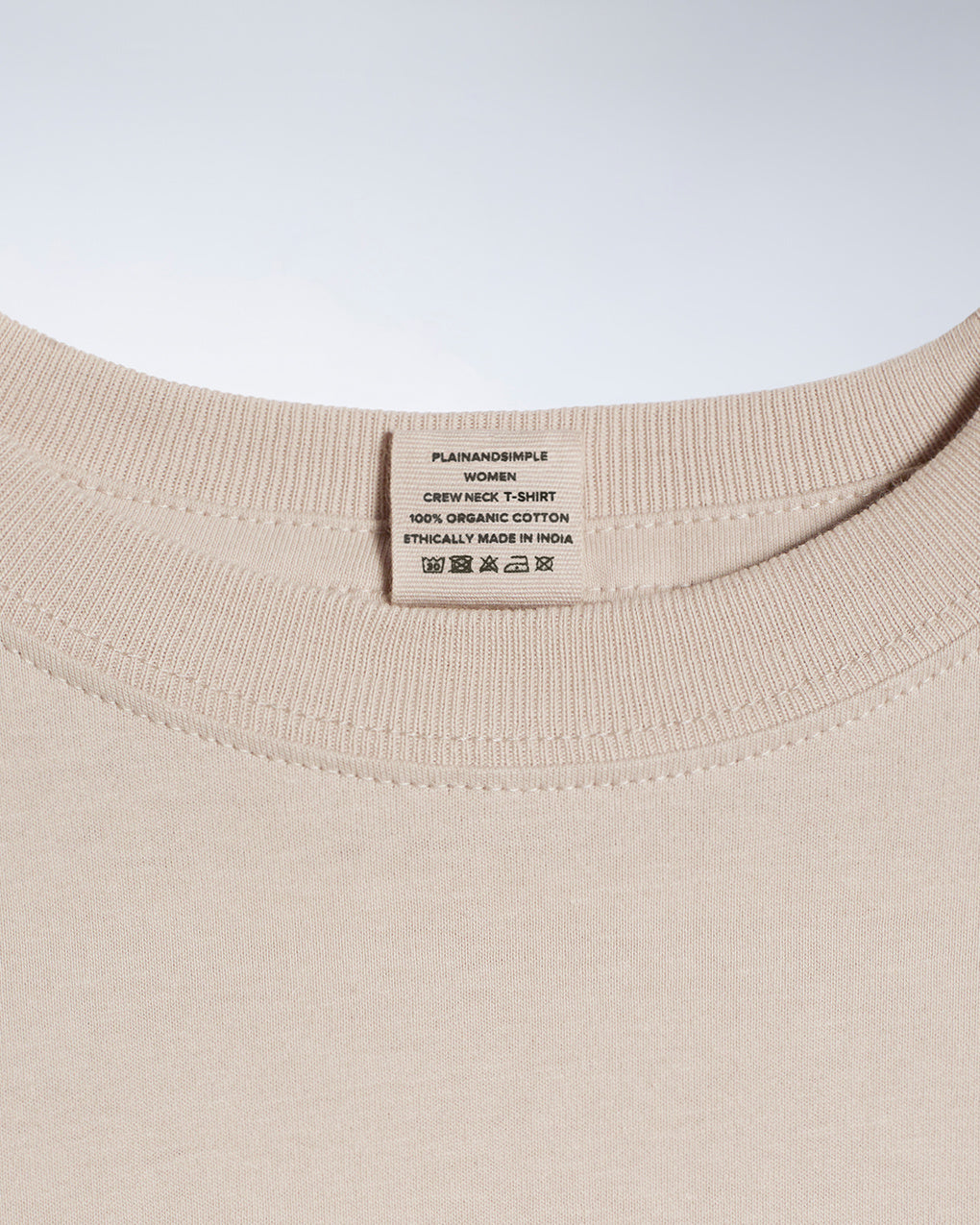 A close up of a neck label in a women's stone short sleeve crew neck organic cotton t shirt.