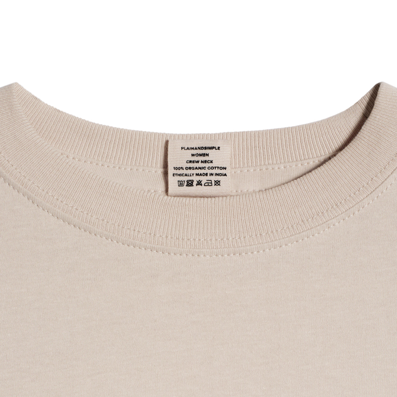 A close up of a neck label in a women's stone short sleeve crew neck organic cotton t shirt.