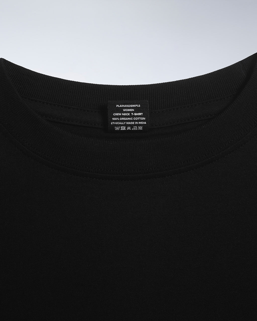 A close up of an neck label in a women's black short sleeve crew neck organic cotton t shirt.