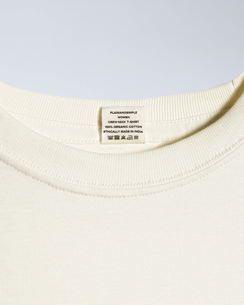 A close up of an neck label in a women's green short sleeve crew neck organic cotton t shirt.