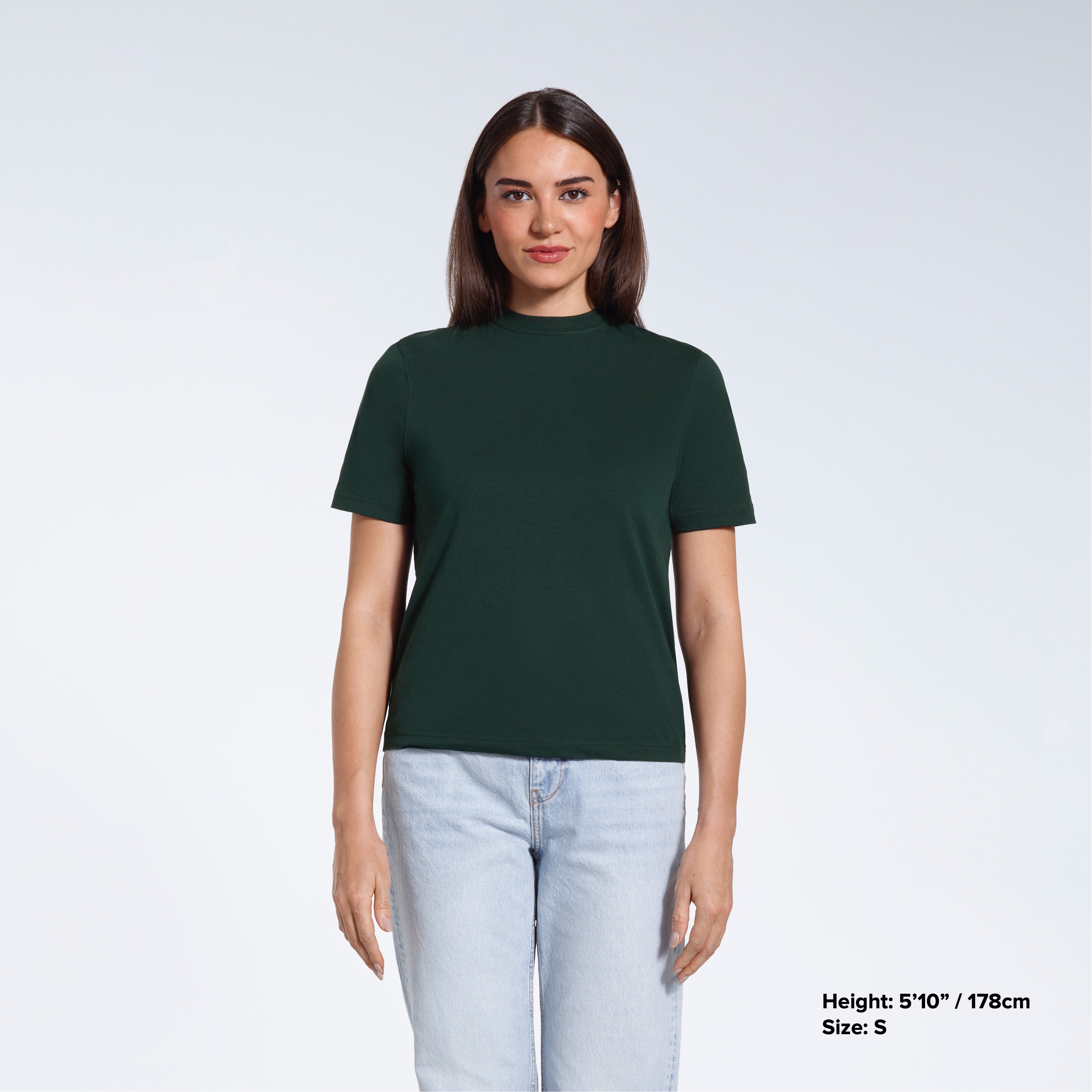 A woman facing front on looking at the camera, modelling a green short sleeve organic cotton t shirt.