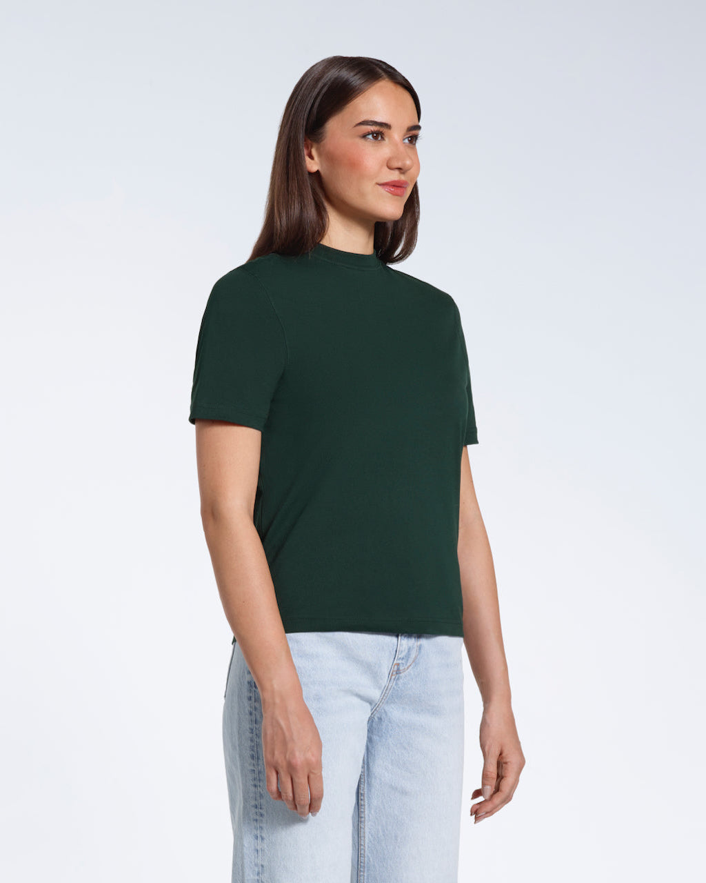 A woman at an angle with her arms at her sides, modelling a plain green short sleeve organic cotton t shirt.