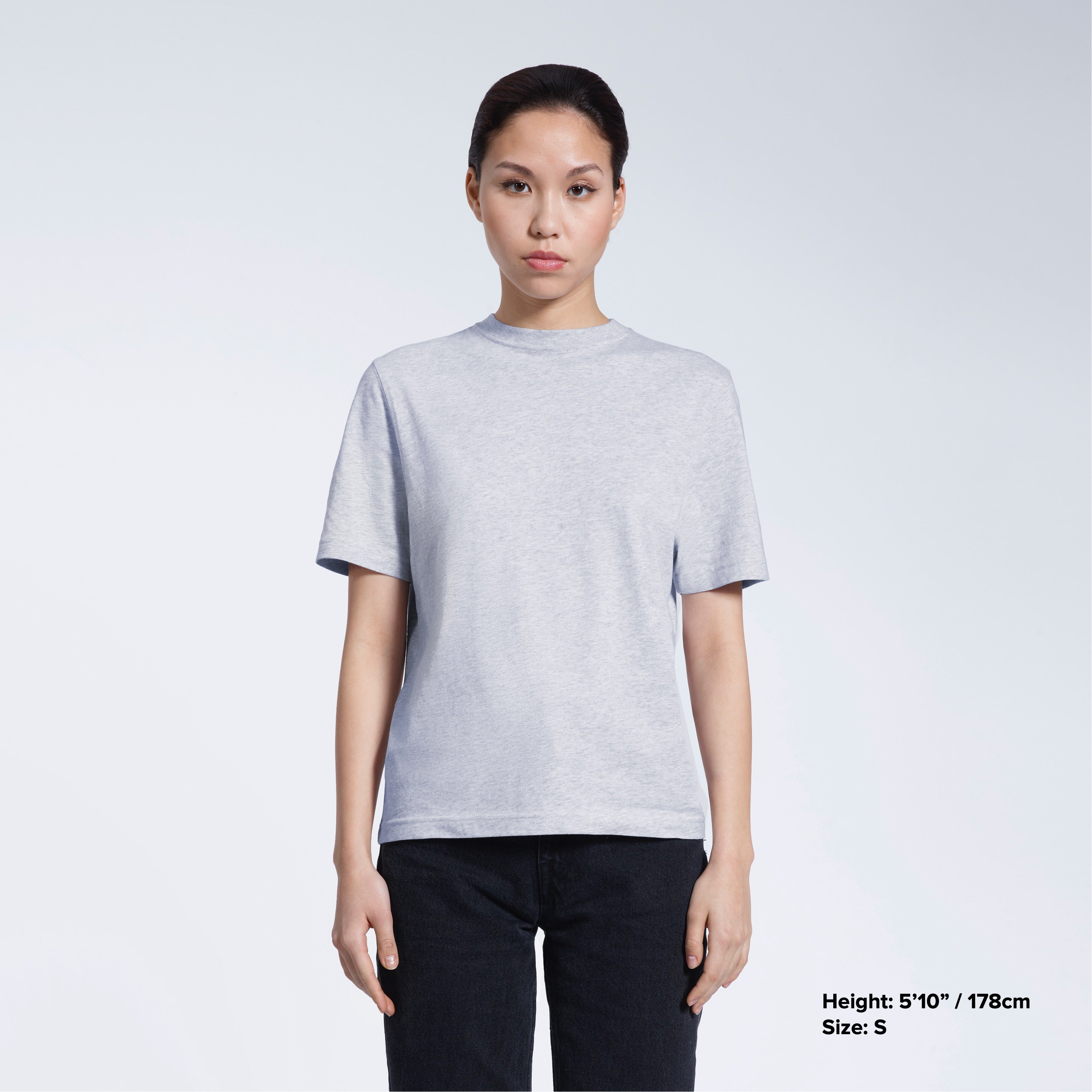 A woman facing front on looking at the camera, modelling a grey short sleeve organic cotton t shirt.