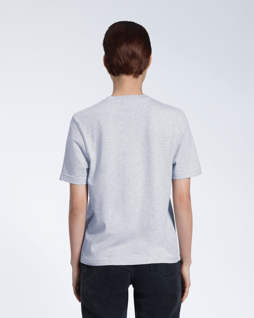 A woman with her back to the camera, modelling a plain grey short sleeve organic cotton t shirt.